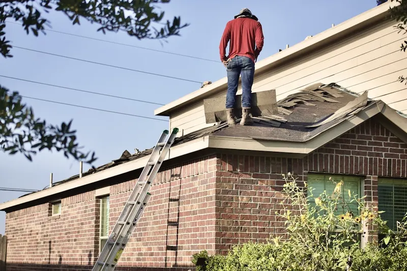 Professional roofer working on a residential roof in Hillyard